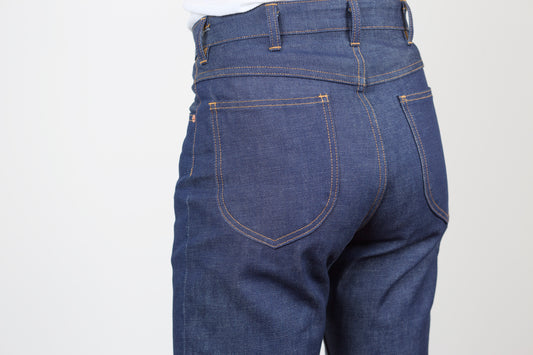 Blue jeans shown from the back on a light gray background